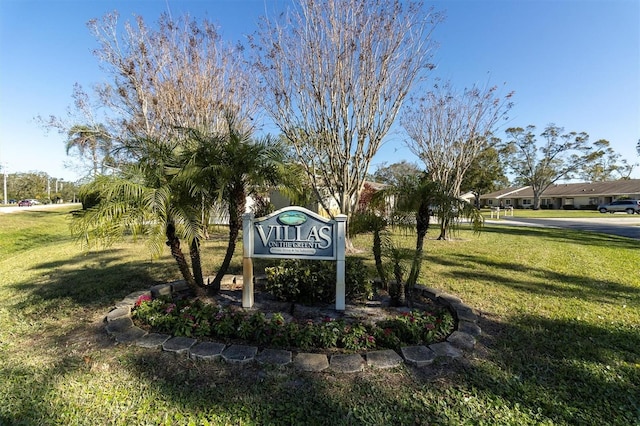 community / neighborhood sign featuring a yard