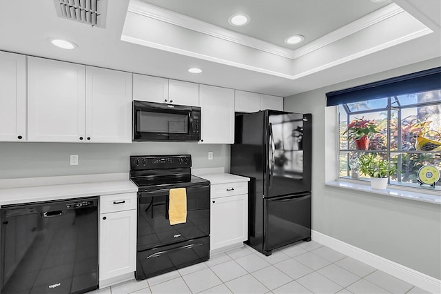 kitchen with white cabinets, a raised ceiling, ornamental molding, and black appliances