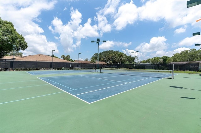 view of tennis court with basketball hoop