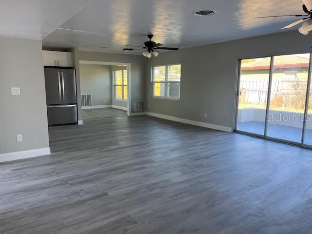 unfurnished living room with hardwood / wood-style flooring and ceiling fan