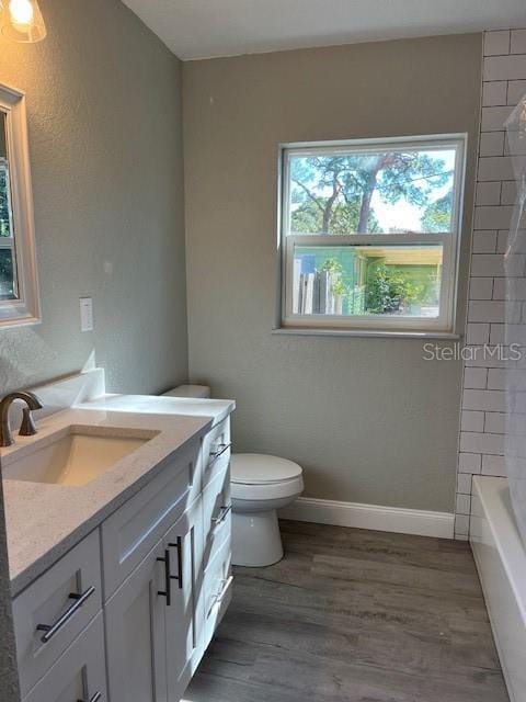 full bathroom with hardwood / wood-style flooring, vanity, toilet, and shower / bath combination