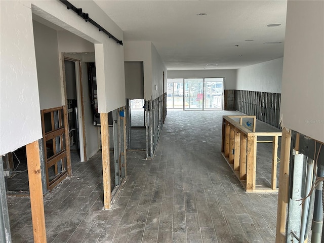 hallway with a barn door and dark hardwood / wood-style flooring