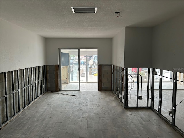 unfurnished room featuring a textured ceiling