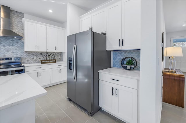 kitchen featuring white cabinets, wall chimney exhaust hood, and stainless steel appliances