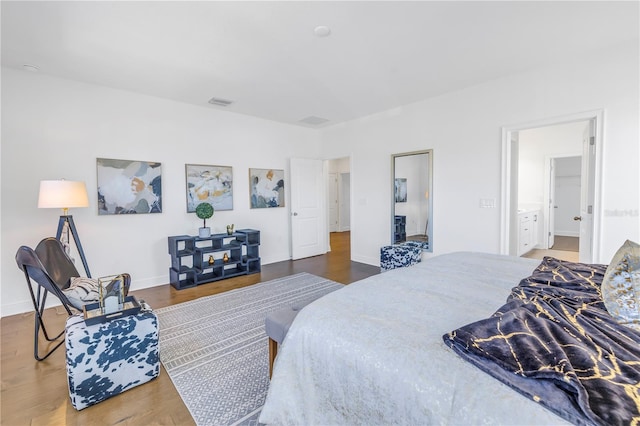 bedroom with wood-type flooring and connected bathroom