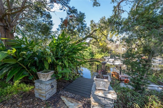 view of yard with a dock and a water view