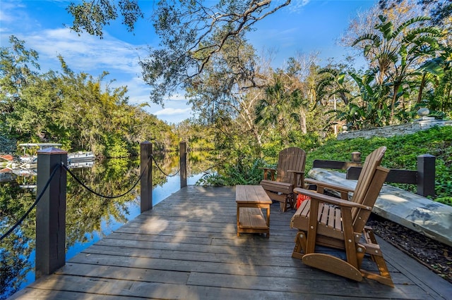 wooden terrace featuring a dock and a water view