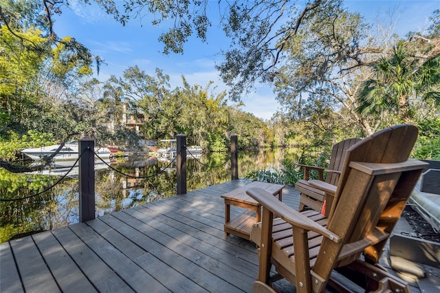 wooden deck with a boat dock and a water view