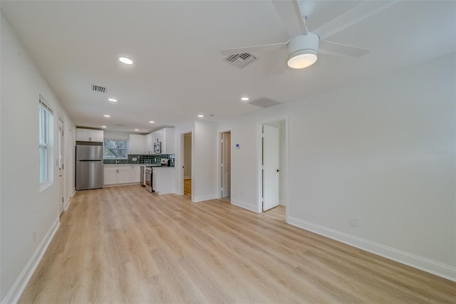 unfurnished living room with ceiling fan and light wood-type flooring