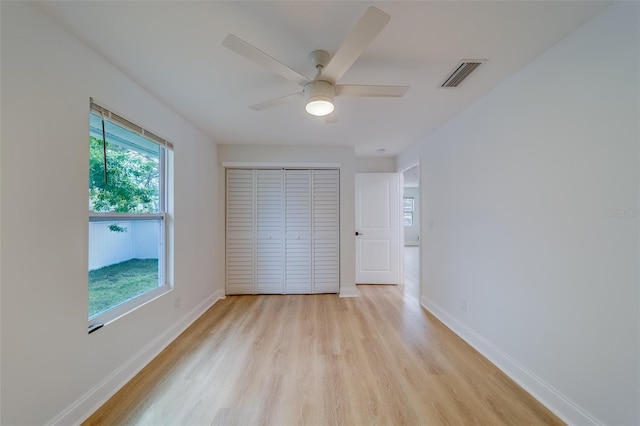 unfurnished bedroom featuring light hardwood / wood-style flooring, a closet, and ceiling fan