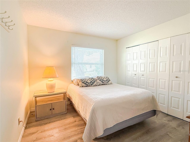 bedroom with light hardwood / wood-style flooring, a closet, and a textured ceiling