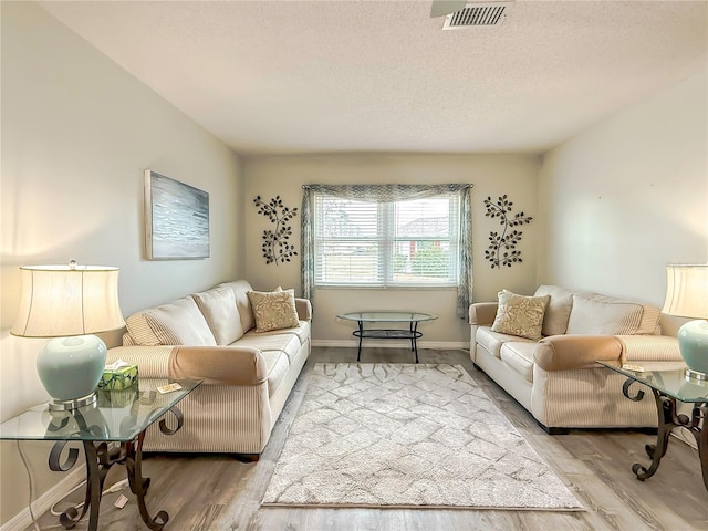 living room featuring light hardwood / wood-style flooring and a textured ceiling