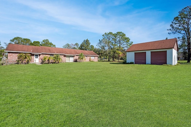 view of yard featuring a garage and an outdoor structure