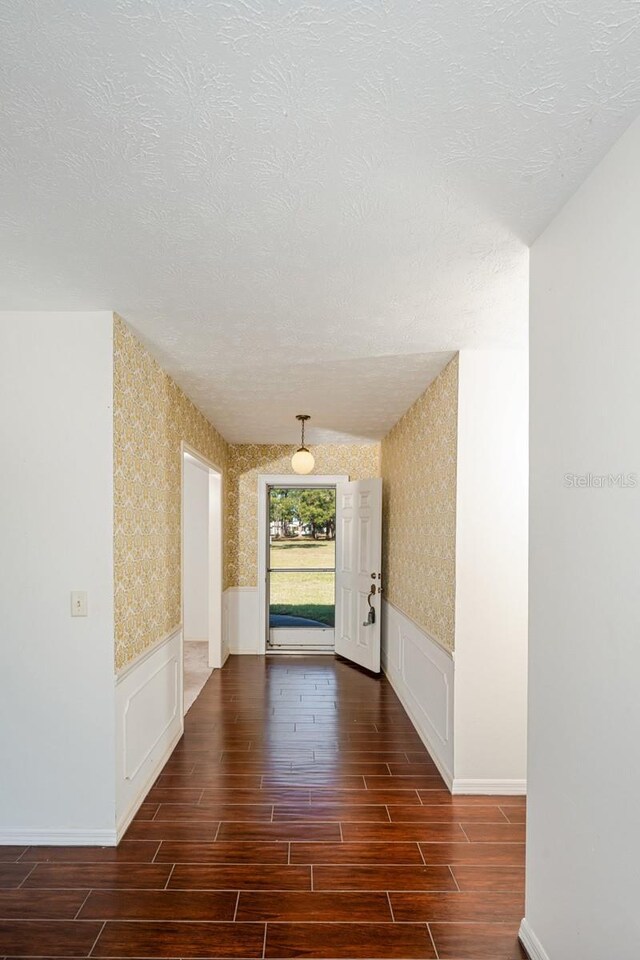 hall featuring a textured ceiling