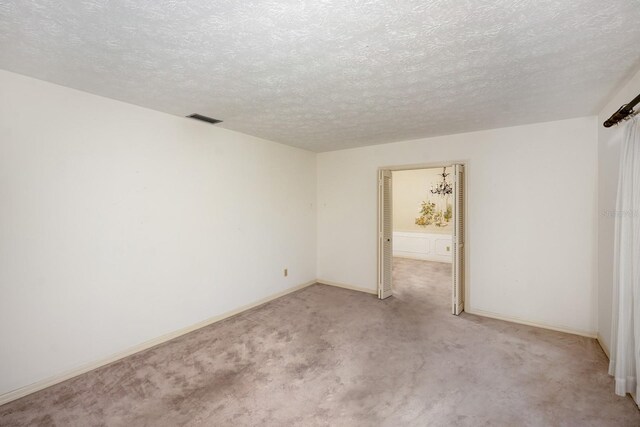 carpeted empty room with a textured ceiling