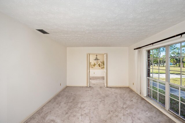 carpeted empty room with a textured ceiling