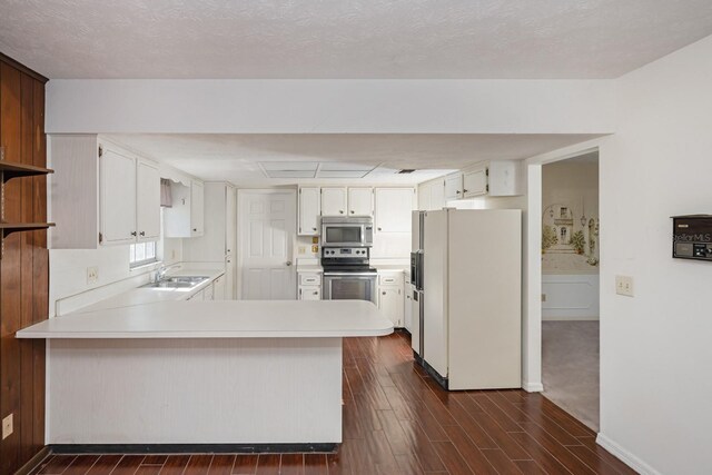 kitchen featuring white cabinetry, sink, kitchen peninsula, and stainless steel appliances