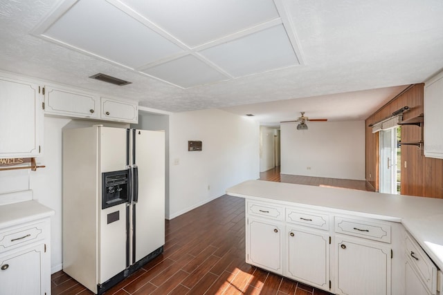 kitchen with ceiling fan, white cabinetry, white refrigerator with ice dispenser, and kitchen peninsula