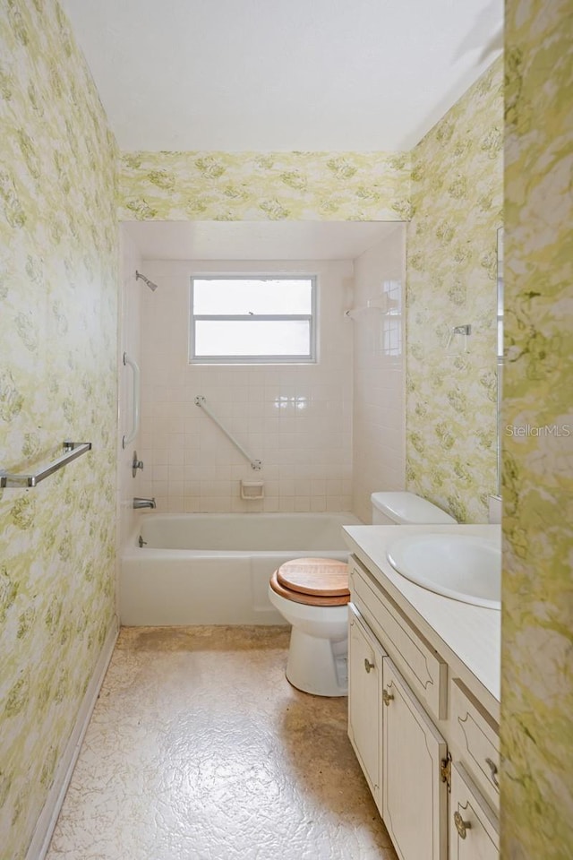 full bathroom featuring vanity, tiled shower / bath combo, and toilet