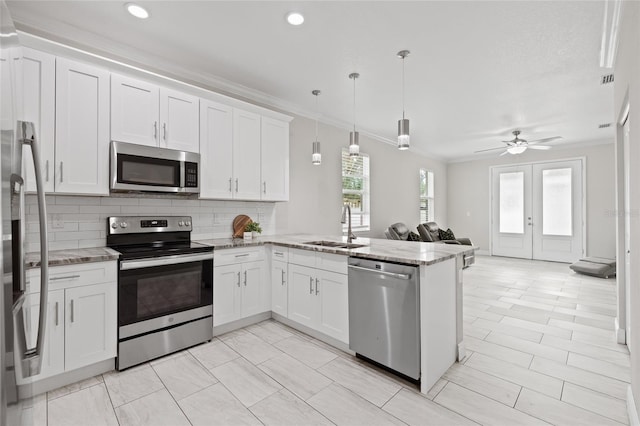 kitchen featuring kitchen peninsula, pendant lighting, white cabinets, and stainless steel appliances