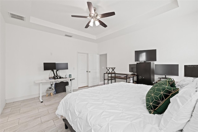 bedroom with a raised ceiling and ceiling fan