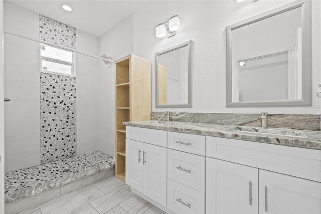 bathroom featuring a tile shower and vanity