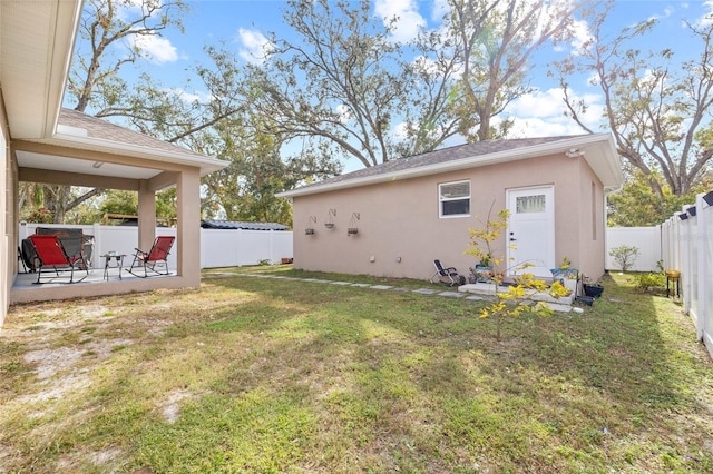 rear view of property with a lawn and a patio