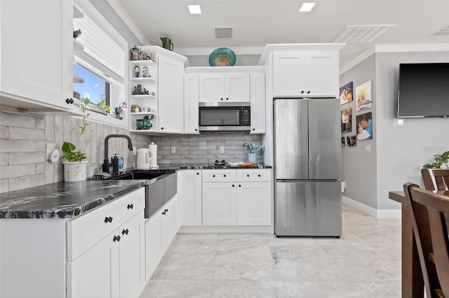 kitchen with appliances with stainless steel finishes, backsplash, and white cabinetry