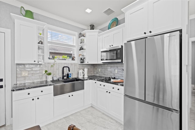 kitchen featuring decorative backsplash, appliances with stainless steel finishes, dark stone countertops, and sink