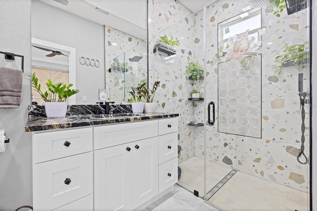 bathroom featuring ceiling fan, a shower with door, and vanity