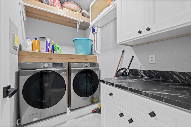 laundry area featuring washer and clothes dryer and cabinets