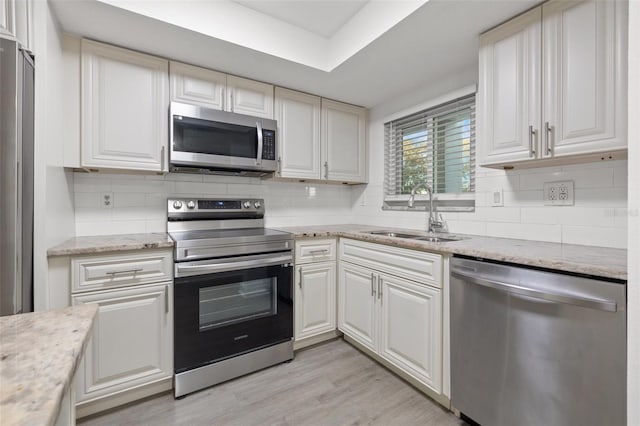 kitchen featuring white cabinetry, light wood-type flooring, sink, and appliances with stainless steel finishes