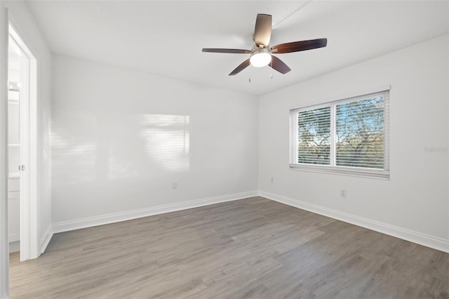 spare room featuring hardwood / wood-style floors, ceiling fan, and a healthy amount of sunlight