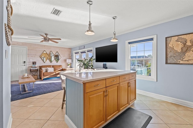 kitchen with a textured ceiling, light tile patterned flooring, and decorative light fixtures