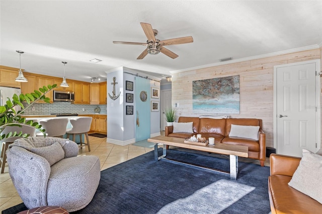 living room with crown molding, ceiling fan, wooden walls, and light tile patterned flooring