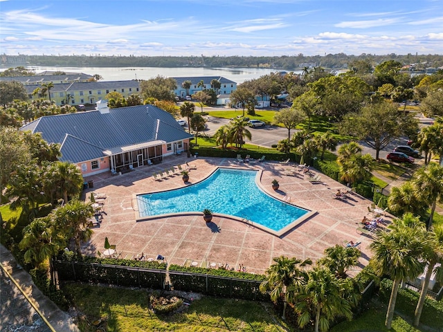 view of swimming pool featuring a water view and a patio