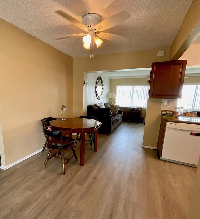 dining area with a textured ceiling, light hardwood / wood-style flooring, and ceiling fan