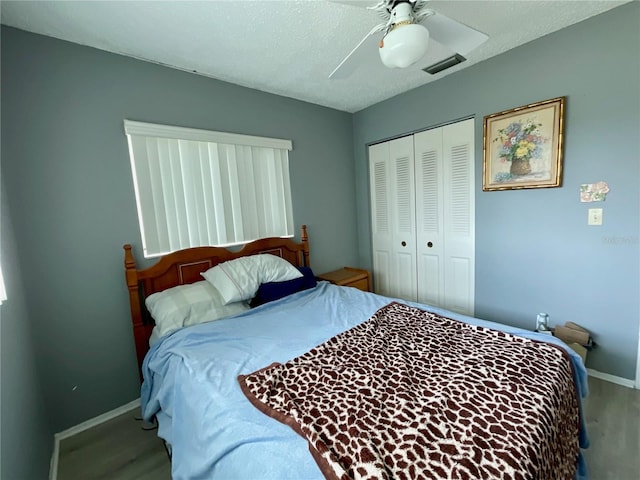 bedroom featuring hardwood / wood-style floors, a textured ceiling, a closet, and ceiling fan