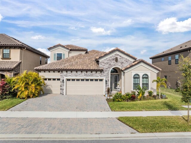 mediterranean / spanish-style house with a front yard and a garage