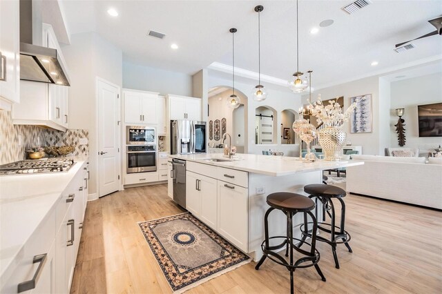 kitchen featuring sink, pendant lighting, a center island with sink, white cabinets, and appliances with stainless steel finishes