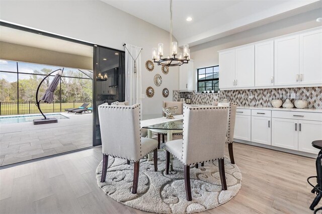 dining room featuring a notable chandelier, plenty of natural light, and light hardwood / wood-style flooring