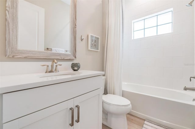 full bathroom with hardwood / wood-style floors, vanity, toilet, and shower / tub combo