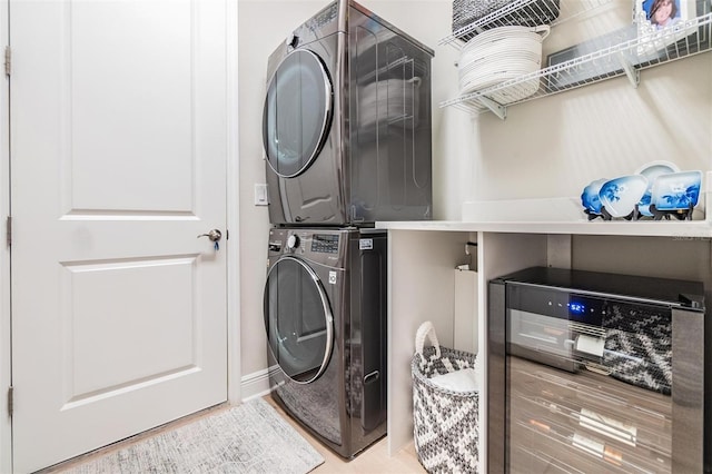 laundry area featuring beverage cooler and stacked washer / drying machine