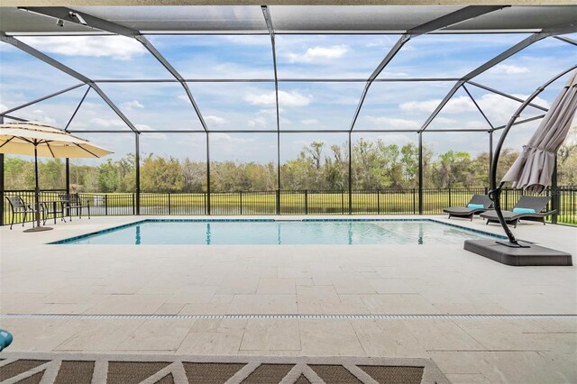 view of swimming pool with a patio area and a lanai