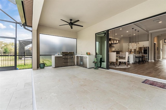 view of patio / terrace featuring ceiling fan, a lanai, grilling area, and an outdoor kitchen