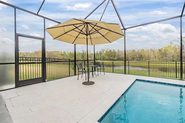 view of swimming pool featuring a lanai, a patio area, and a water view