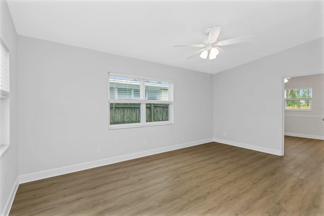 empty room featuring ceiling fan, dark hardwood / wood-style flooring, and a wealth of natural light