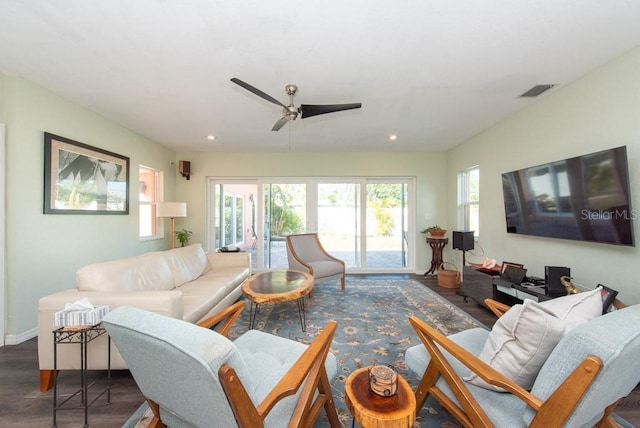 living room with ceiling fan and dark wood-type flooring