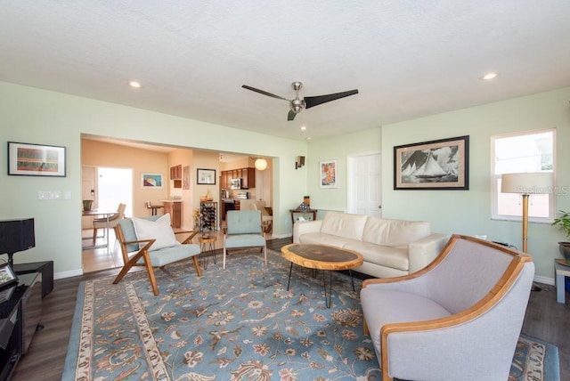 living room with dark hardwood / wood-style floors and ceiling fan