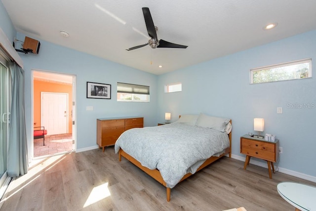 bedroom with ceiling fan, light hardwood / wood-style floors, multiple windows, and vaulted ceiling